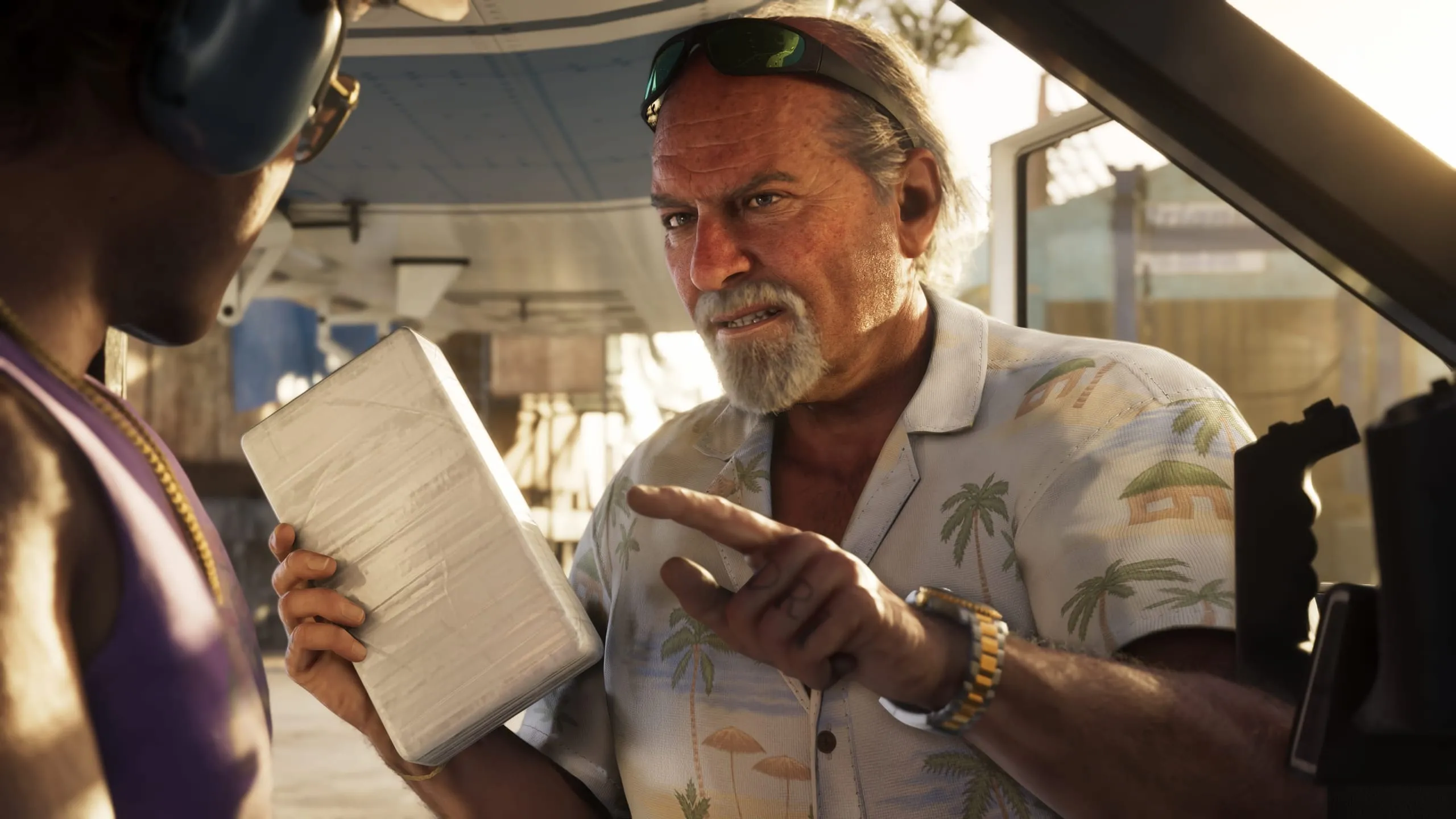 Man in a palm-print shirt pointing at a taped white brick held out by another man