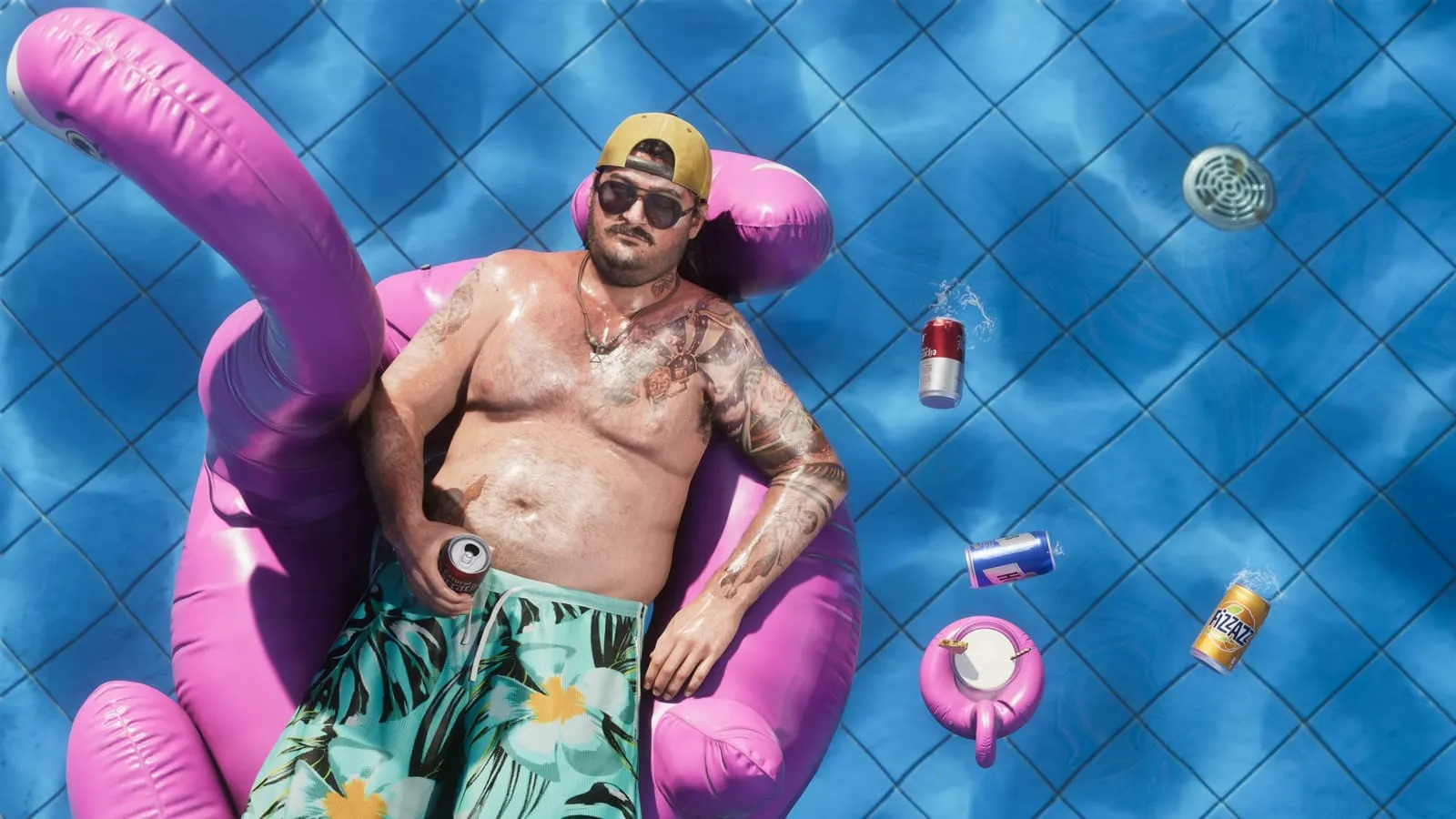 Vue du dessus, homme sur une bouée flamant rose dans une piscine, canettes autour