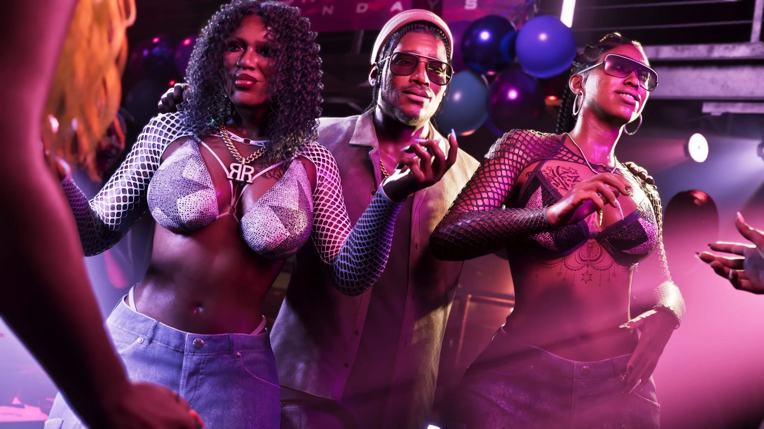 Two women in stagewear flank a man in tinted glasses under pink club lights