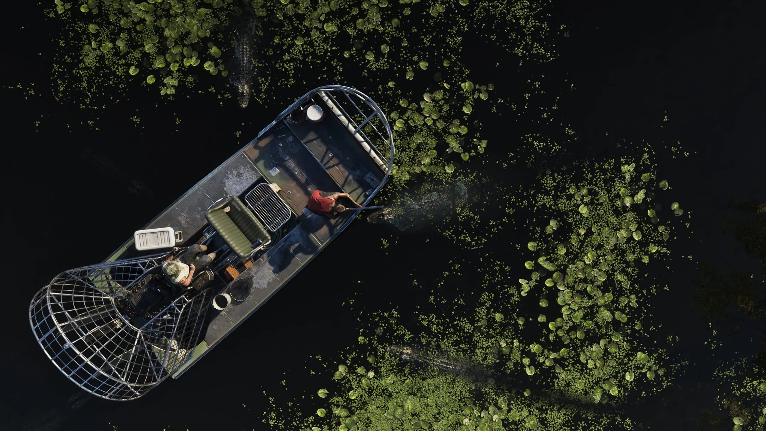 Top-down view of an airboat on black water, two people aboard as alligators circle through the lily pads