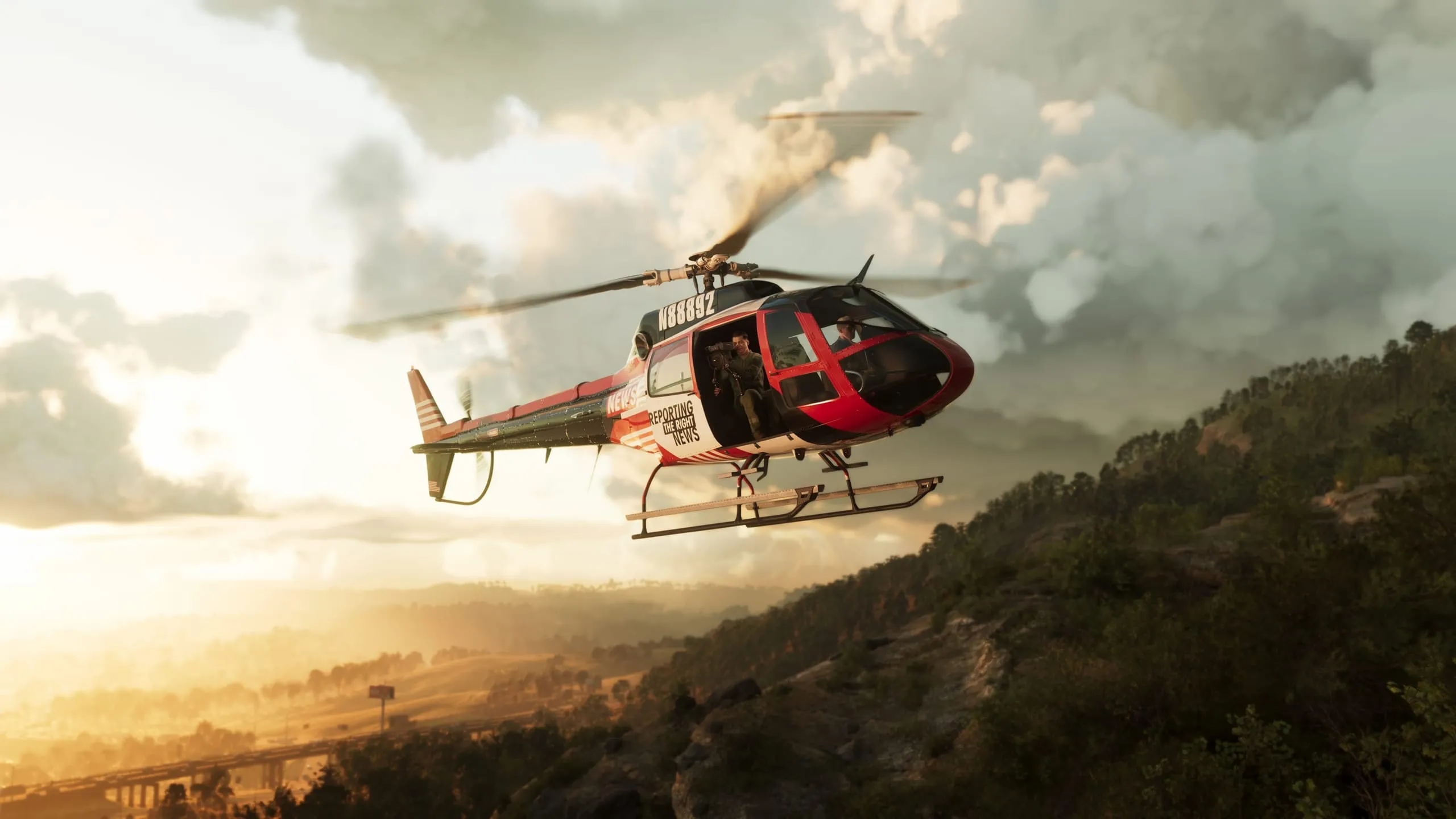 TV news helicopter banking over a wooded ridge at sunset with a cameraman filming