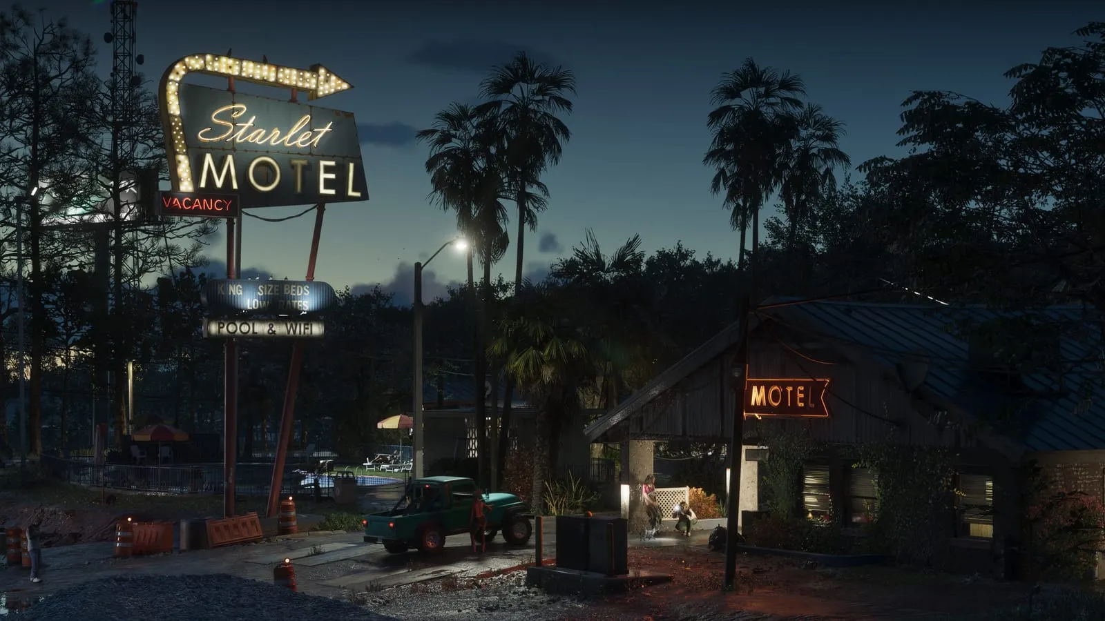 Enseigne néon du Starlet Motel et pick-up vert sur un parking de nuit, palmiers en arrière-plan