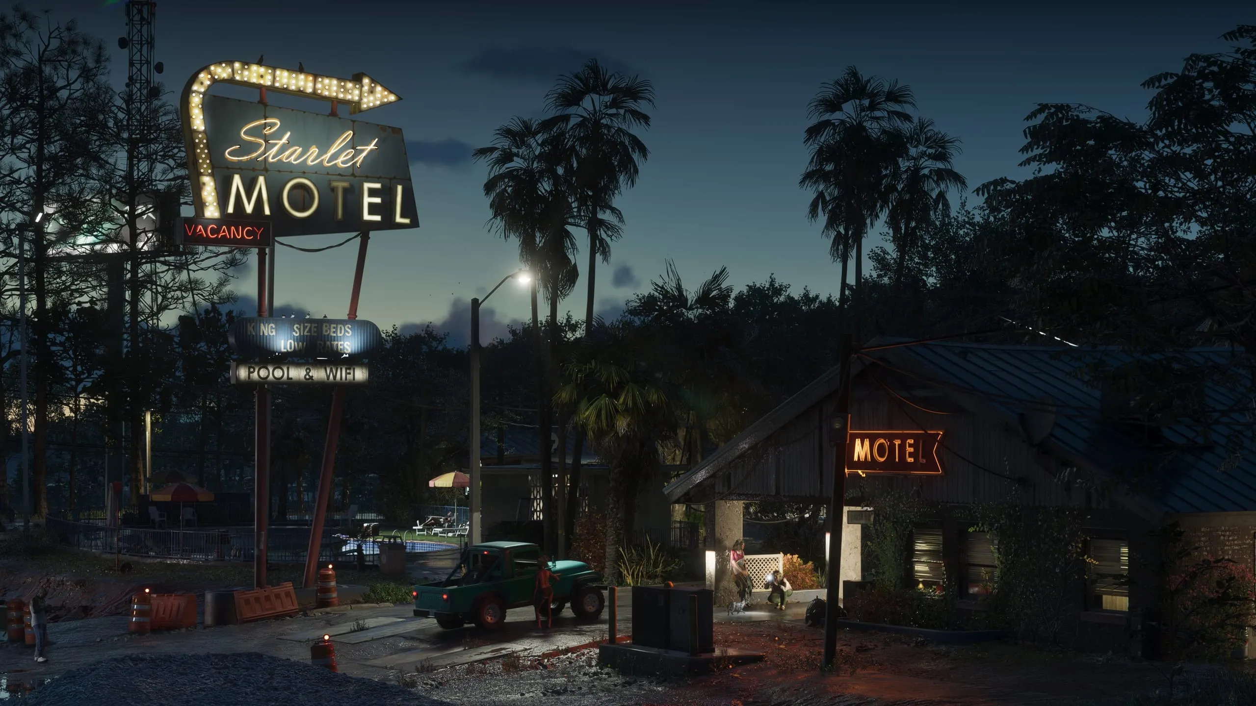 Starlet Motel neon sign glowing over a roadside parking lot at dusk, green pickup truck parked outside
